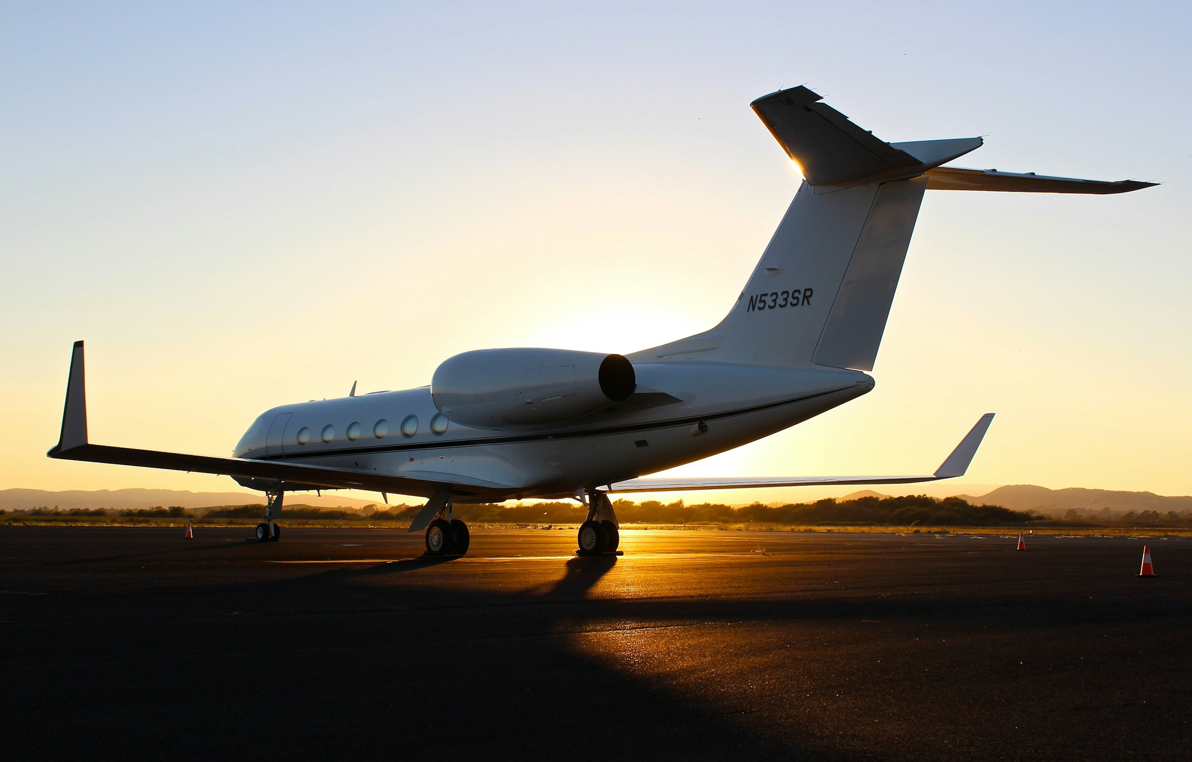 Jato executivo em solo no terminal privativo durante o pôr do sol